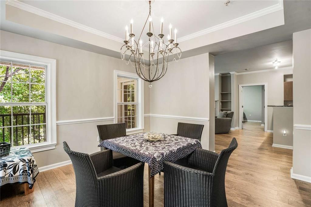 3275 Lenox Road Northeast, Unit 302 Atlanta, GA 30324 - Photo 14 of 50 a view of a dining room with furniture a chandelier and wooden floor