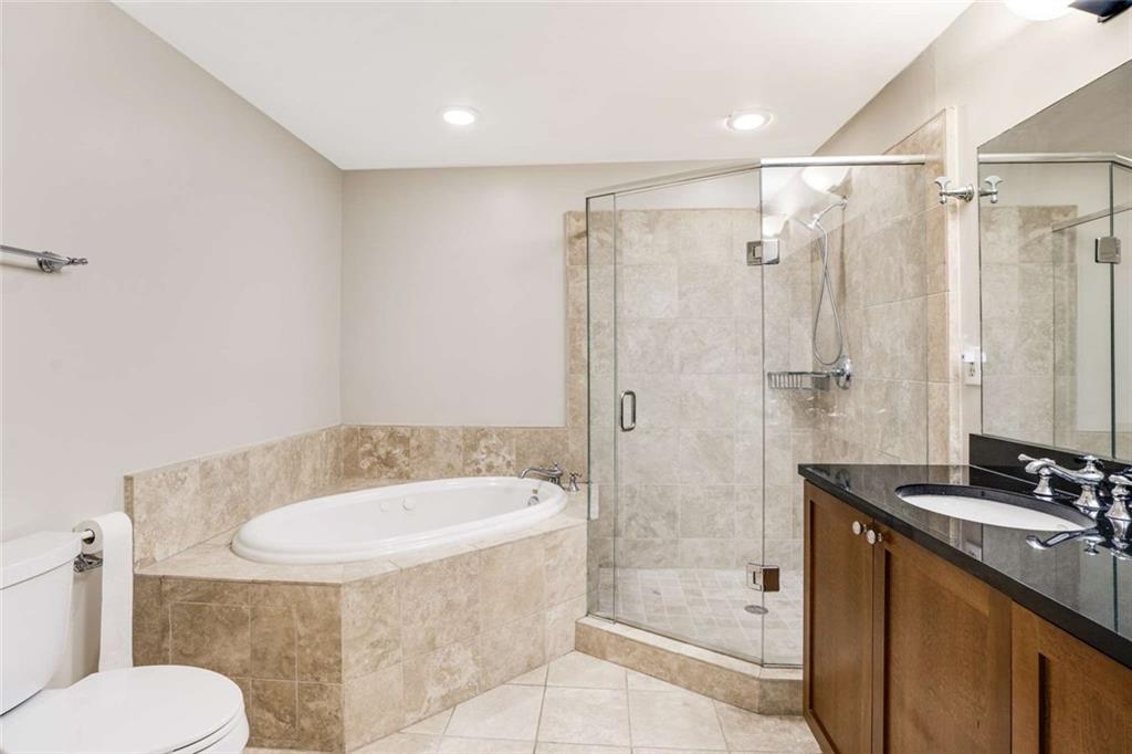 3275 Lenox Road Northeast, Unit 302 Atlanta, GA 30324 - Photo 21 of 50 a bathroom with a granite countertop sink toilet and shower