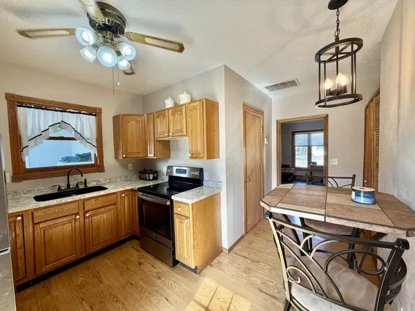 a kitchen with stainless steel appliances granite countertop a sink a stove and refrigerator