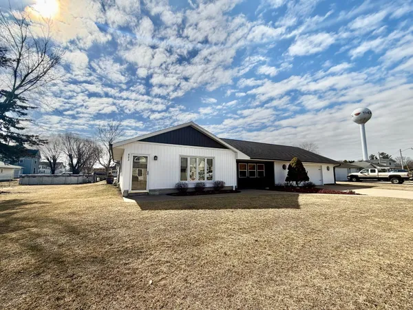 a wooden house with a yard and large trees