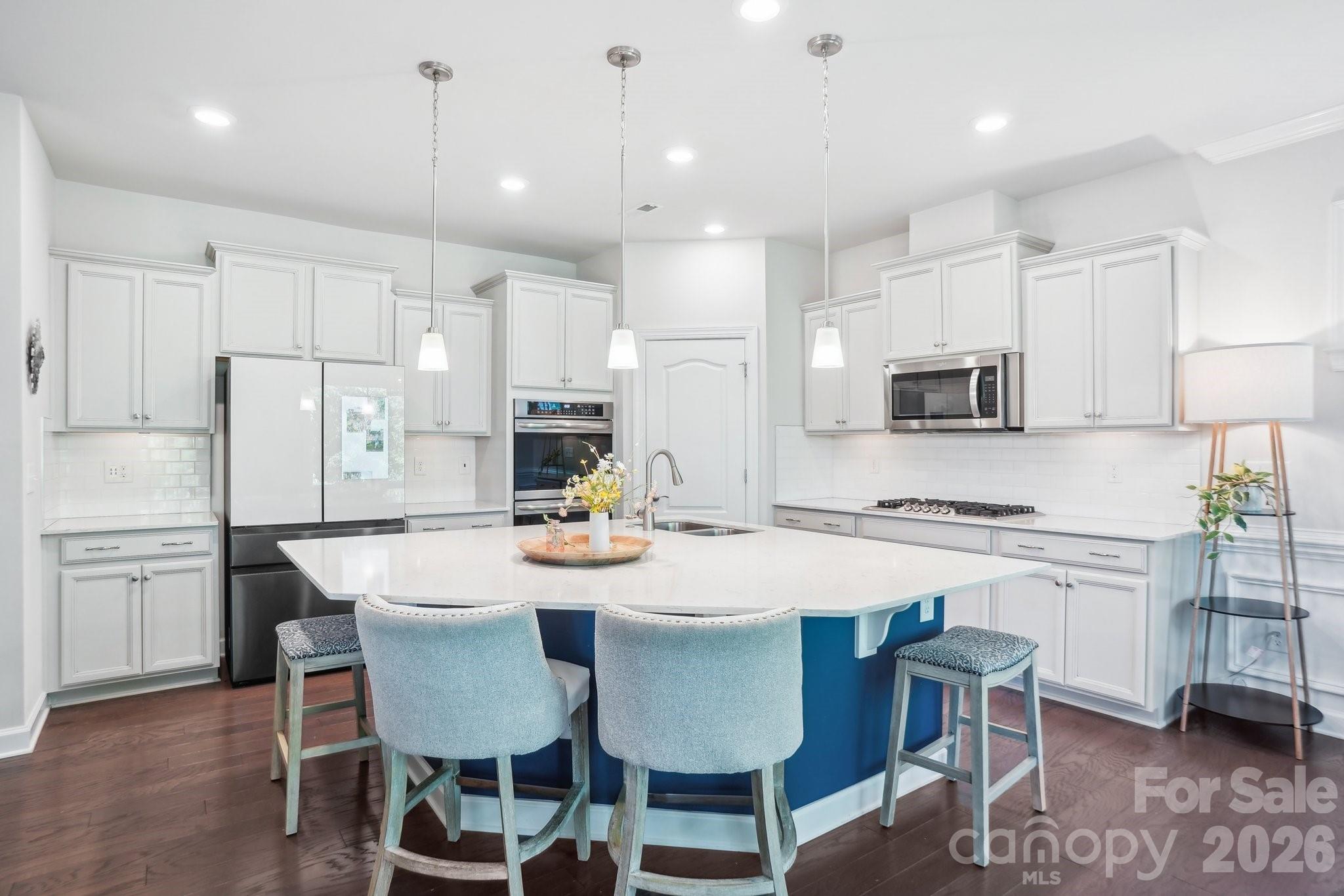 16427 Cozy Cove Road Charlotte, NC 28278 - Photo 12 of 47 a kitchen with stainless steel appliances kitchen island granite countertop a dining table and chairs