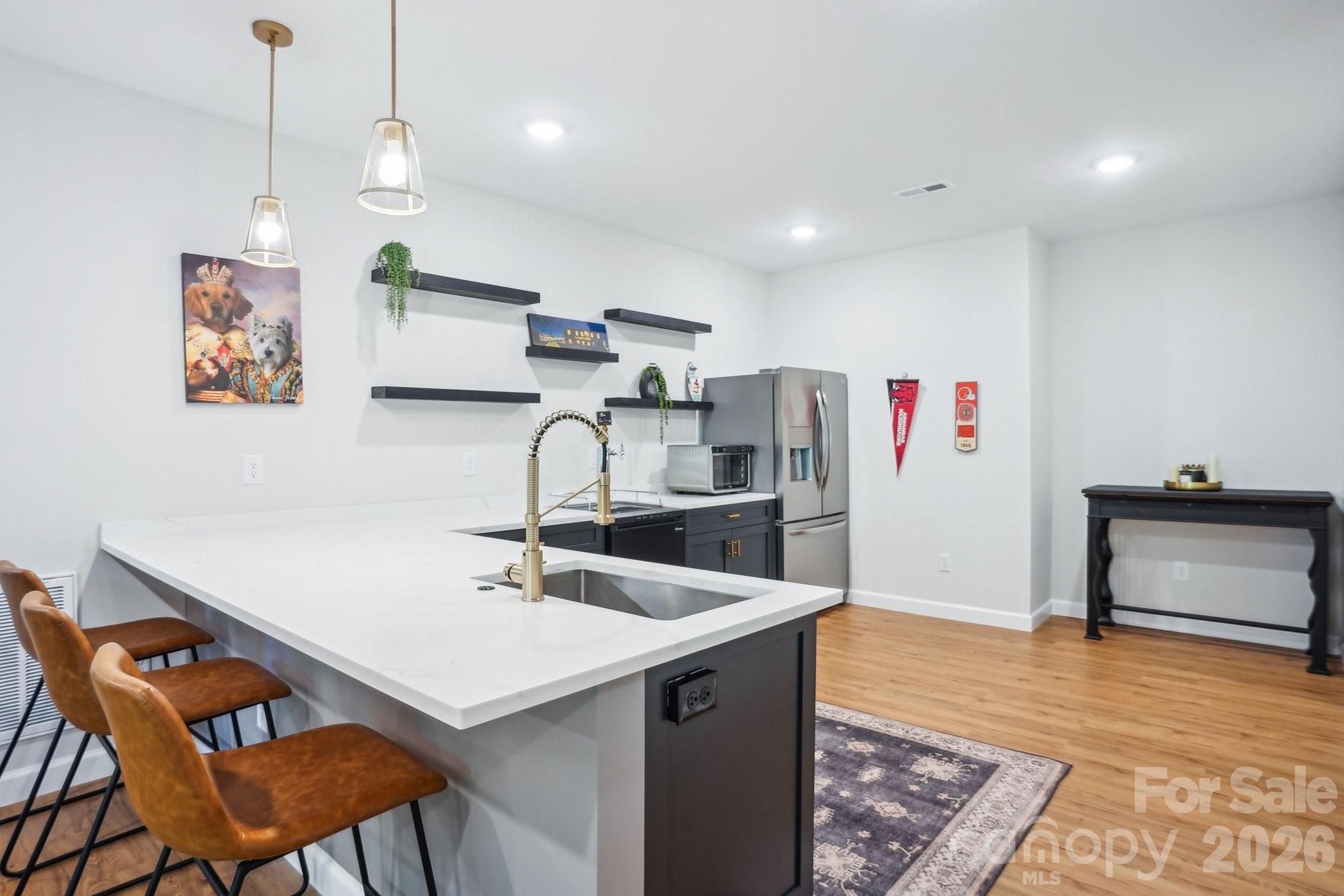 16427 Cozy Cove Road Charlotte, NC 28278 - Photo 23 of 47 a kitchen with stainless steel appliances kitchen island a white cabinets and chairs
