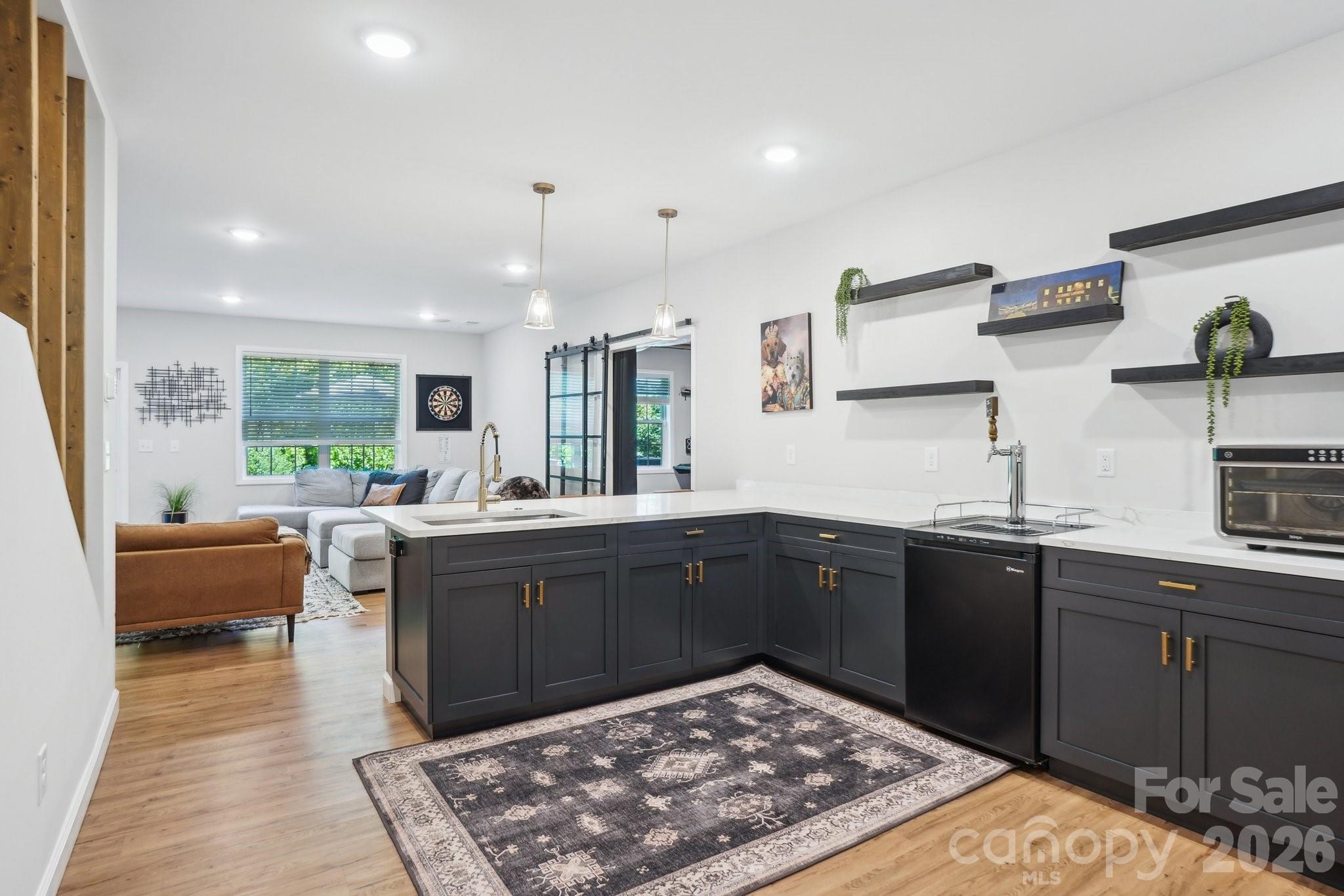 16427 Cozy Cove Road Charlotte, NC 28278 - Photo 24 of 47 a kitchen with stainless steel appliances granite countertop sink stove and white cabinets with wooden floor