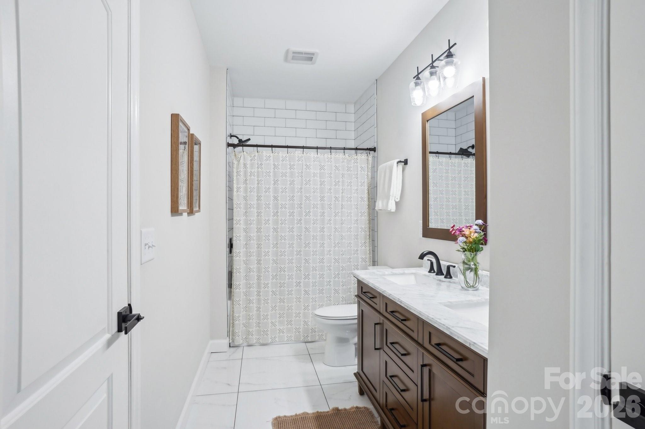 16427 Cozy Cove Road Charlotte, NC 28278 - Photo 30 of 47 a bathroom with a double vanity sink toilet and shower