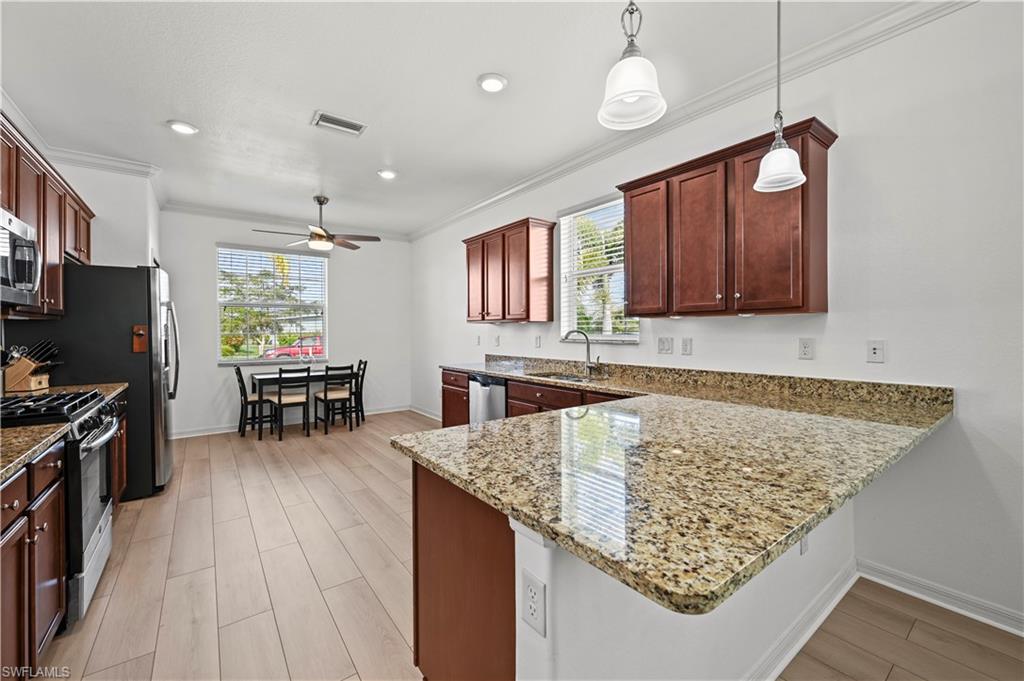 17549 Timberline Parkway Babcock Ranch, FL 33982 - Photo 7 of 39 a kitchen with stainless steel appliances granite countertop wooden cabinets a stove top oven a sink and dishwasher