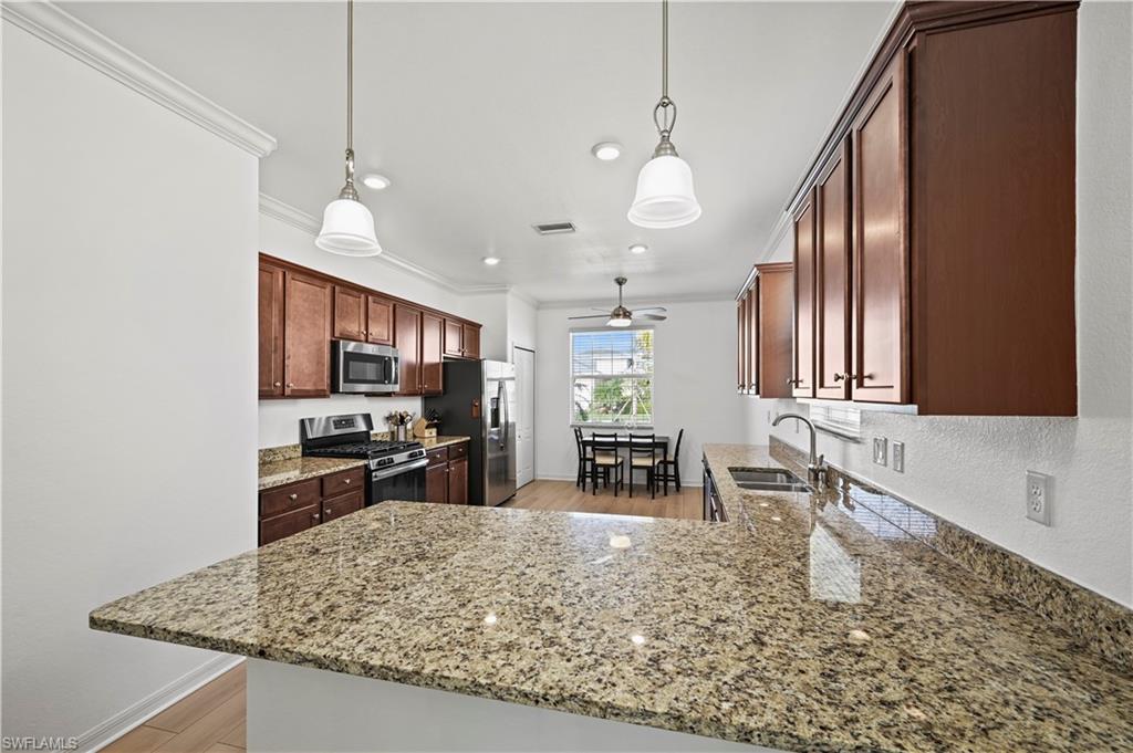 17549 Timberline Parkway Babcock Ranch, FL 33982 - Photo 9 of 39 a kitchen with stainless steel appliances granite countertop sink stove top oven and cabinets
