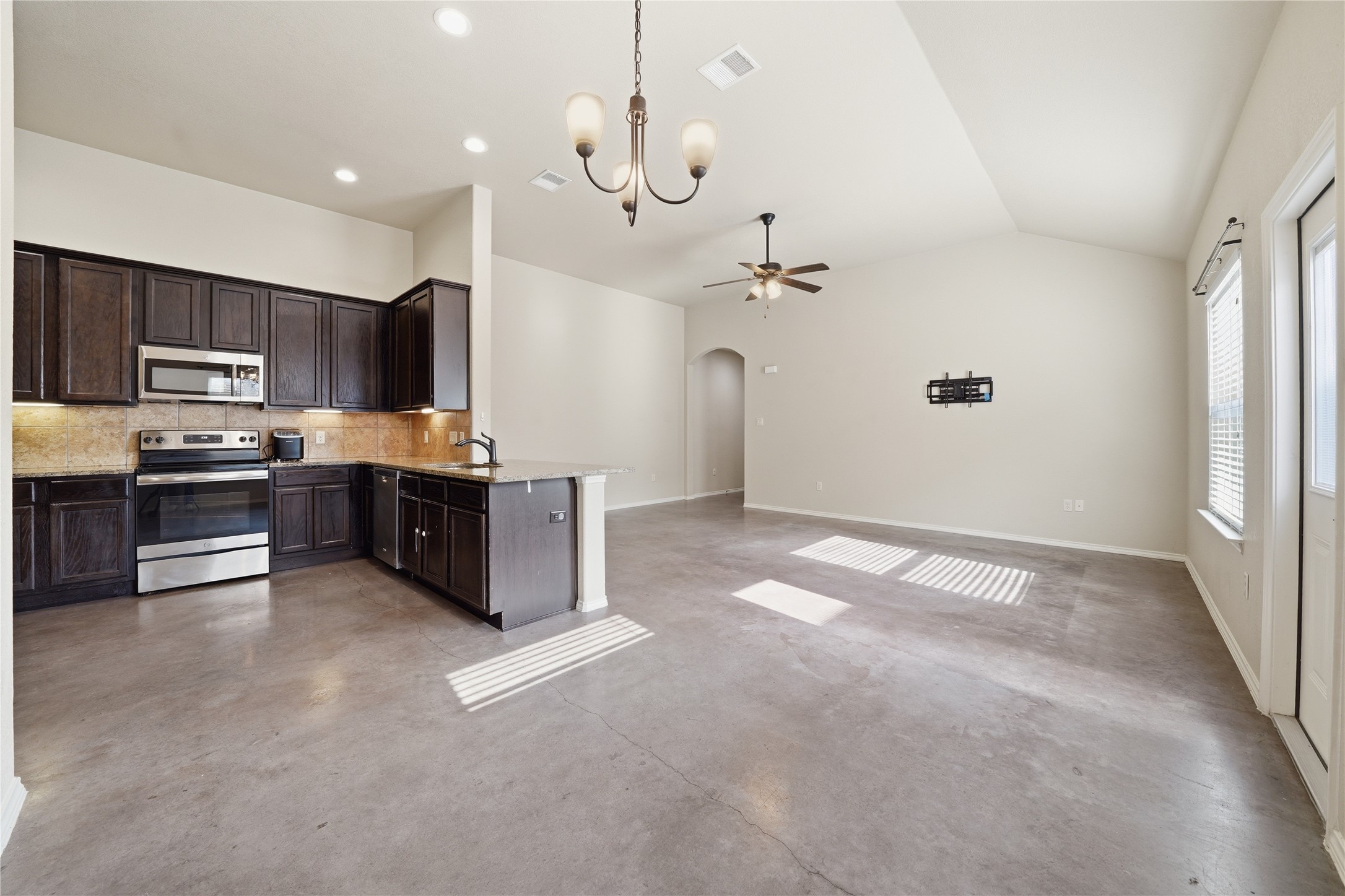533 Jack Rabbit Lane, Unit A Buda, TX 78610 - Photo 2 of 34 An open-concept living area boasts a functional kitchen with an eat-in island, seamlessly flowing into a spacious living room.