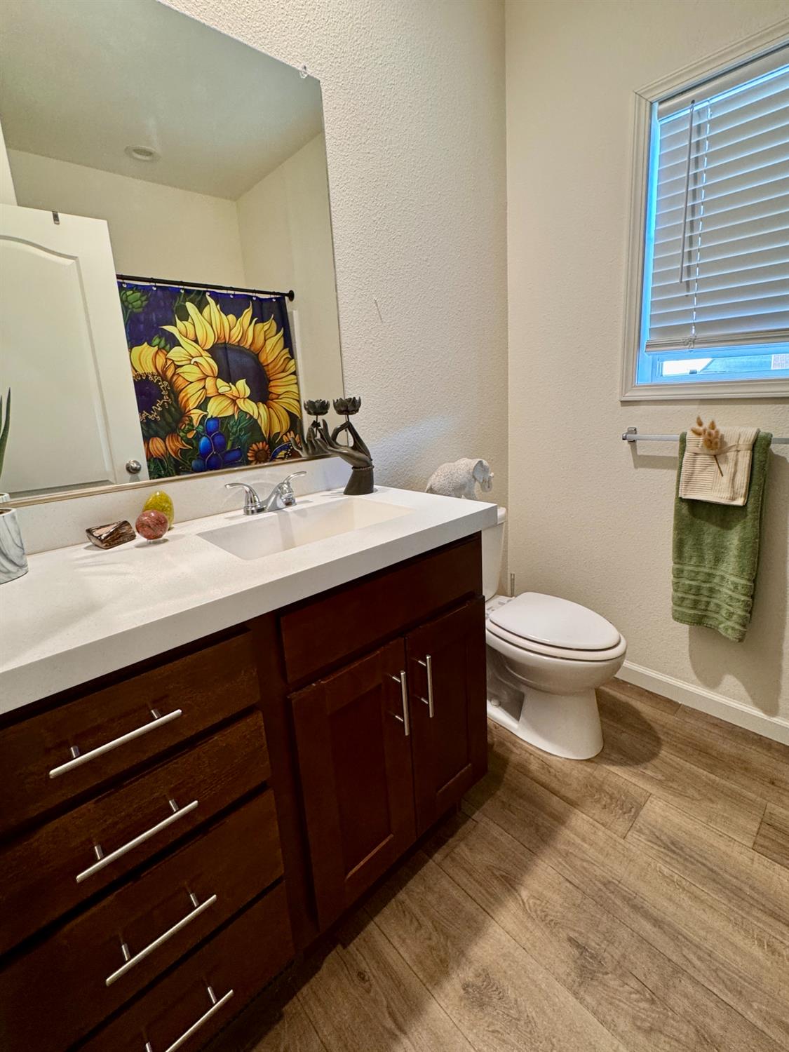 360 East Grant Line Road, Unit 16 Tracy, CA 95376 - Photo 12 of 36 Bathroom featuring a dark wood-finish vanity with a white countertop and integrated sink, a window with horizontal blinds, and wood-finish flooring