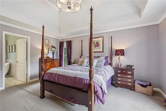 a bedroom with a bed chandelier and a window