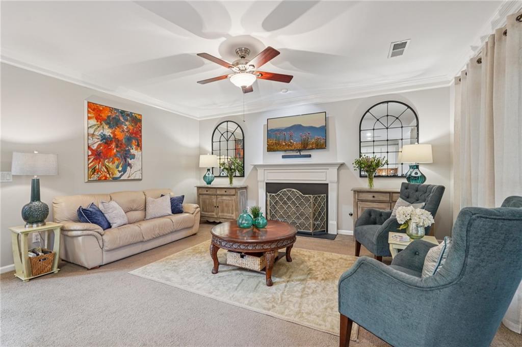 3820 Ridge Point Drive Suwanee, GA 30024 - Photo 8 of 41 a living room with furniture a fireplace and a flat screen tv