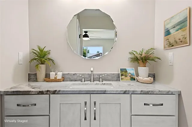 a bathroom with a granite countertop sink and a mirror