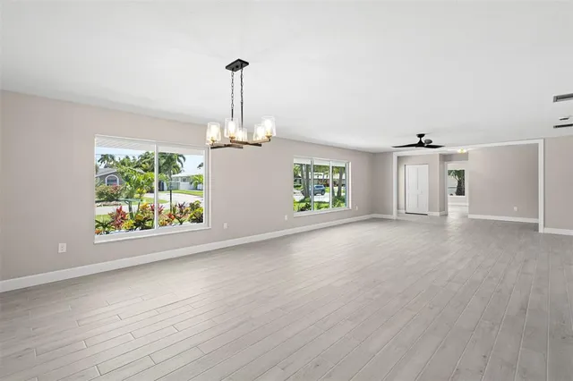 an empty room with windows and fan view