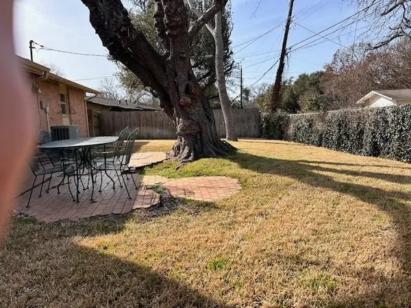 a view of a backyard with table and chairs under an umbrella