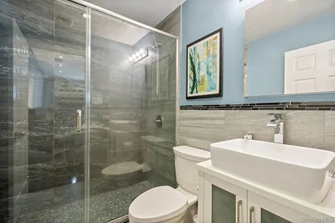 a bathroom with a toilet a sink and glass door
