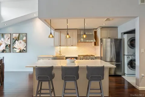 a kitchen with stainless steel appliances granite countertop a refrigerator and a stove top oven