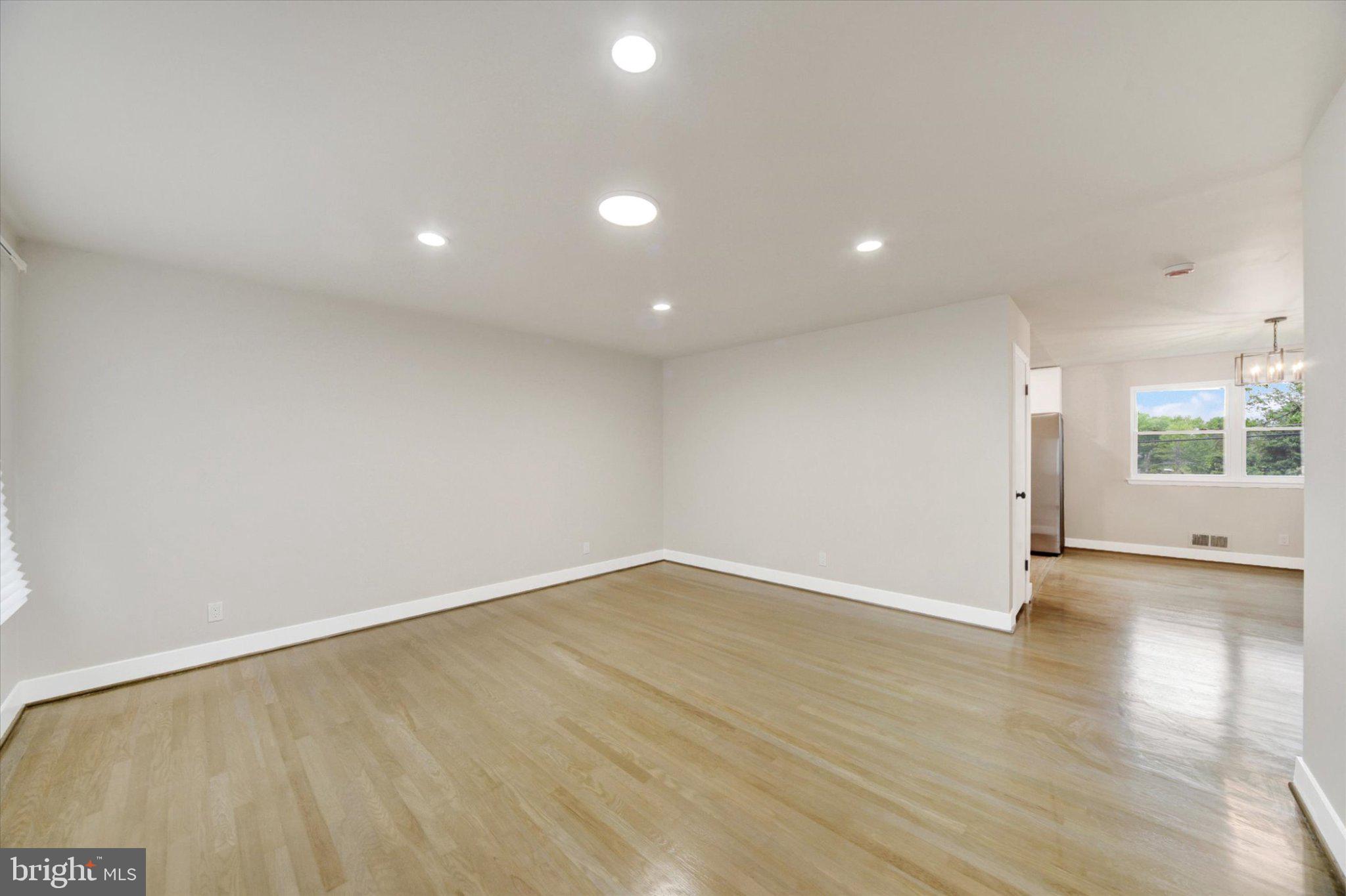 3709 Lamoine Road Randallstown, MD 21133 - Photo 5 of 25 an empty room with wooden floor and windows