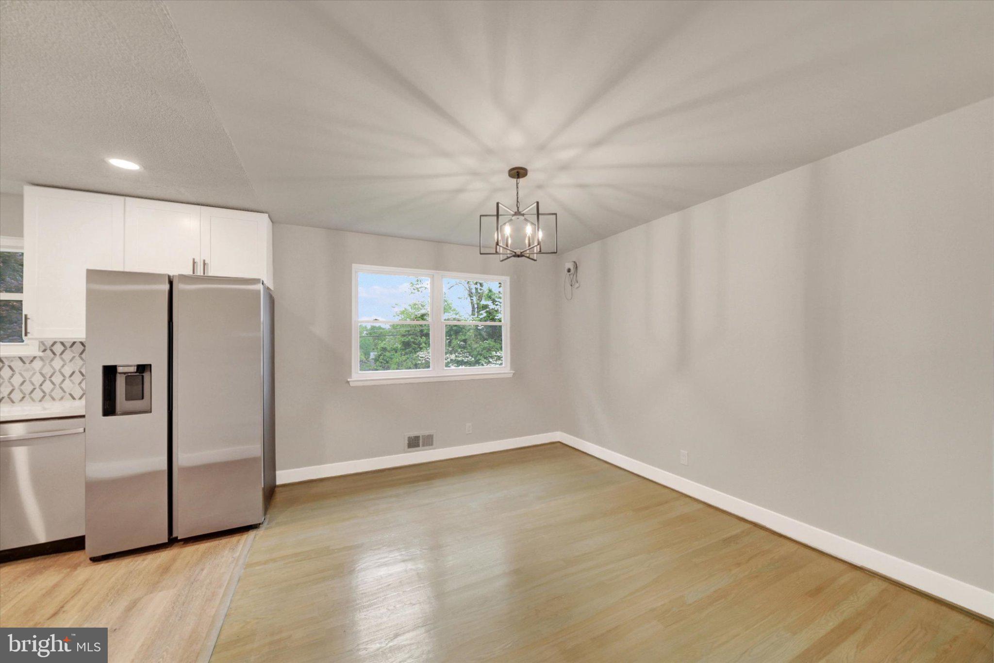 3709 Lamoine Road Randallstown, MD 21133 - Photo 6 of 25 a view of a livingroom with a chandelier fan and refrigerator