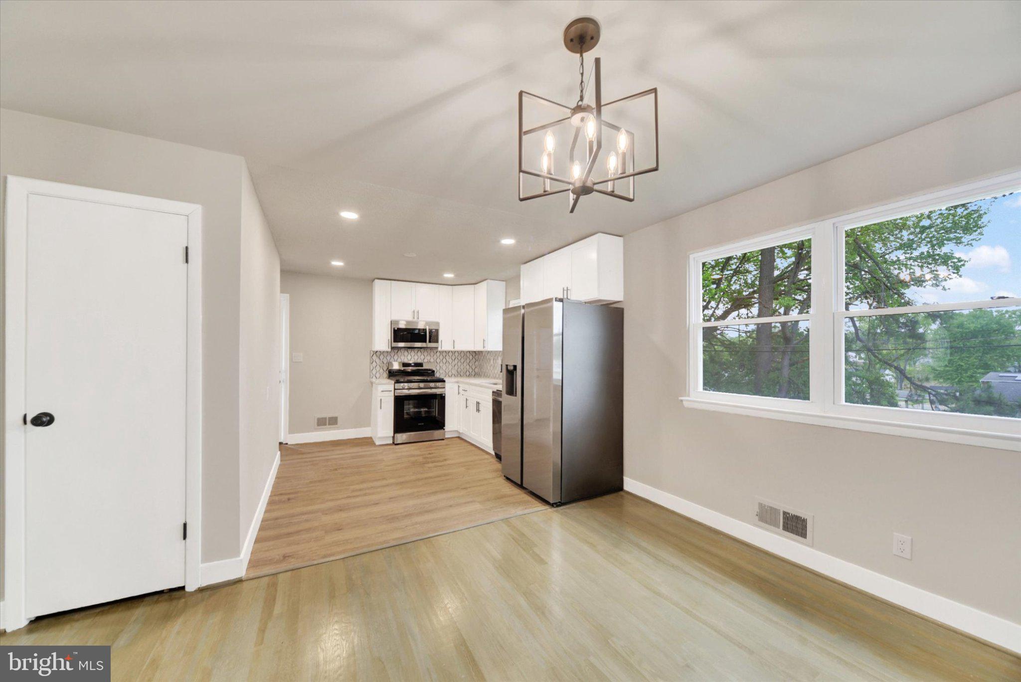 3709 Lamoine Road Randallstown, MD 21133 - Photo 7 of 25 a view of a kitchen with a ceiling fan a refrigerator and windows