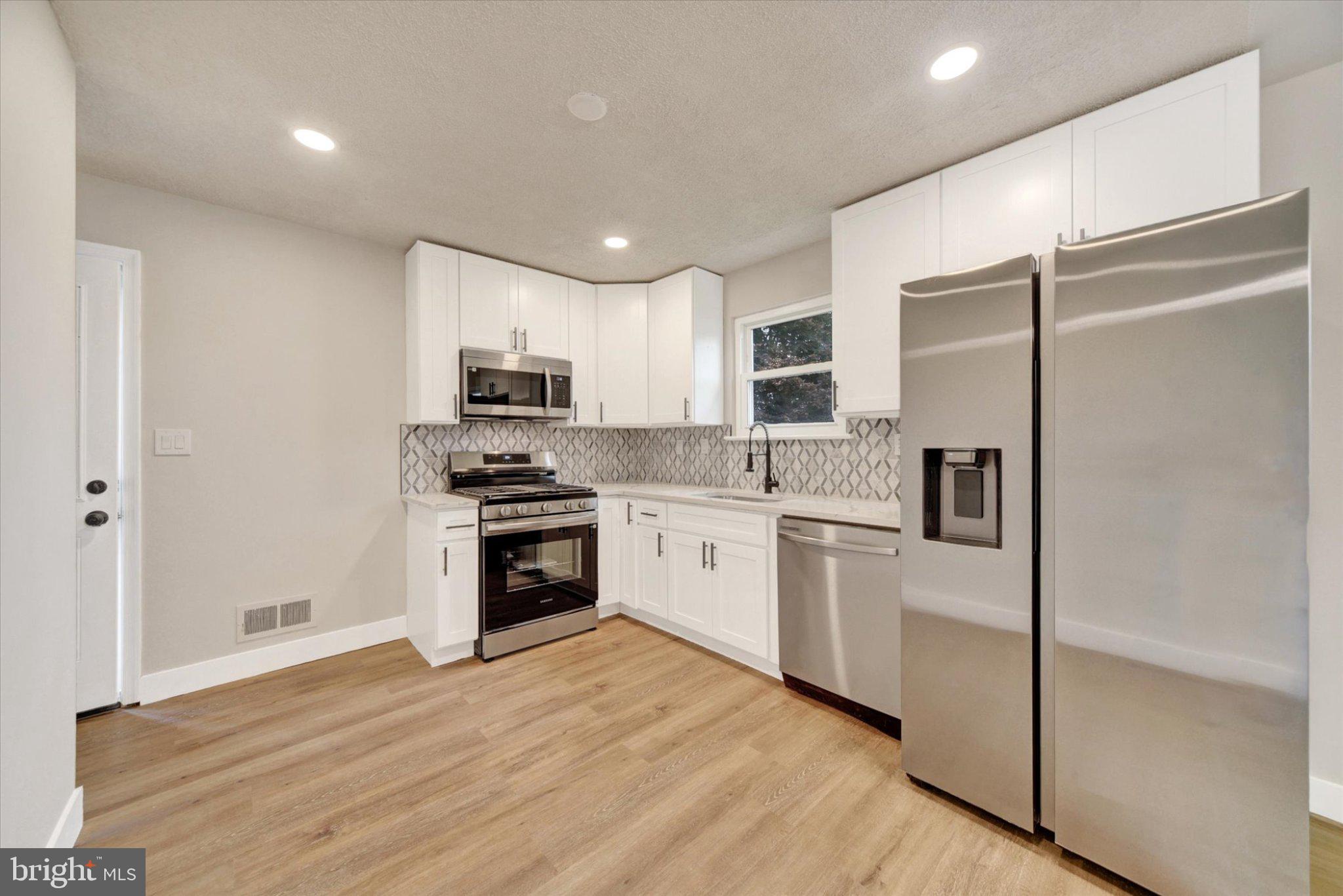 3709 Lamoine Road Randallstown, MD 21133 - Photo 8 of 25 a kitchen with a refrigerator stove and microwave