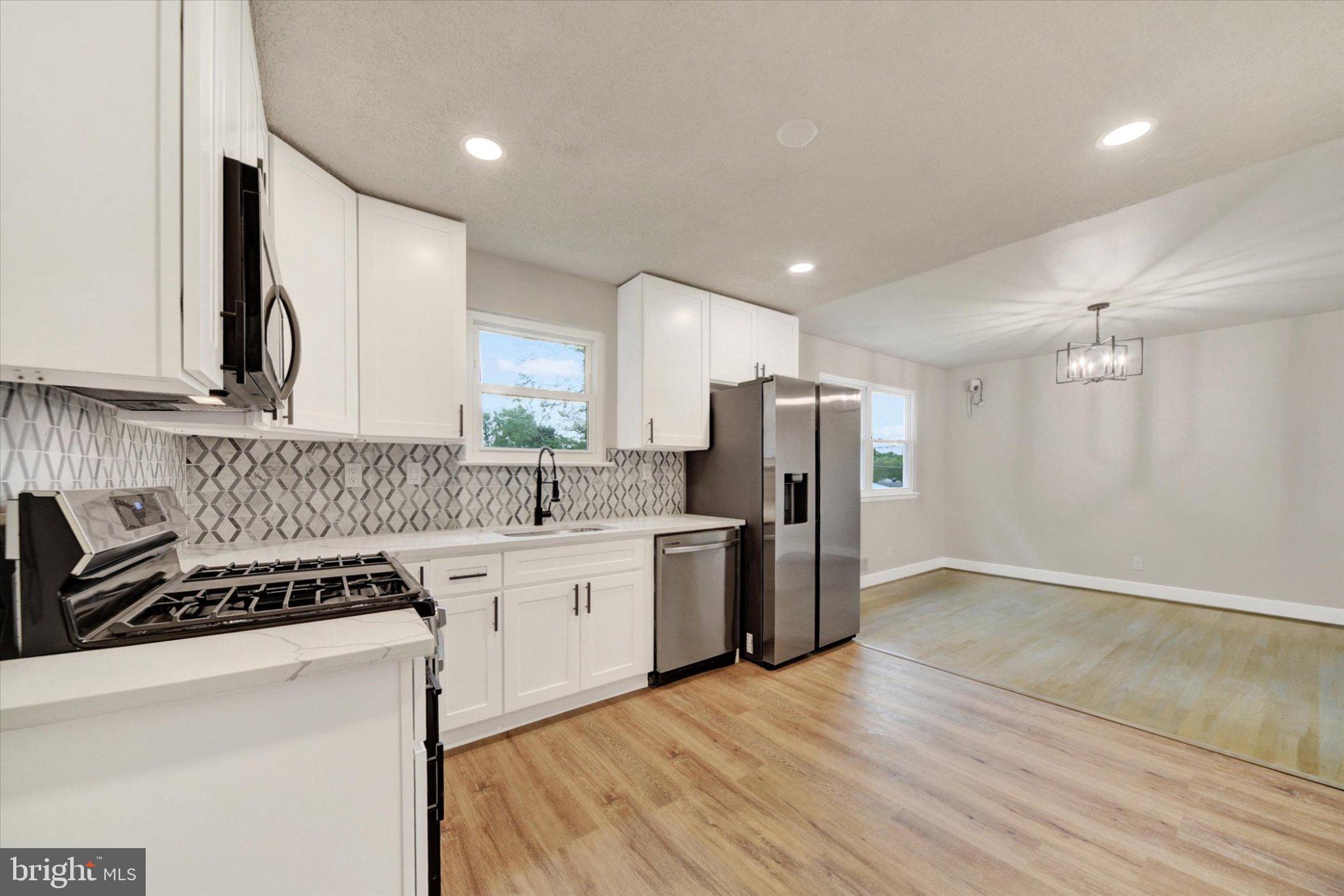 3709 Lamoine Road Randallstown, MD 21133 - Photo 9 of 25 a kitchen with a refrigerator a sink and a stove top oven