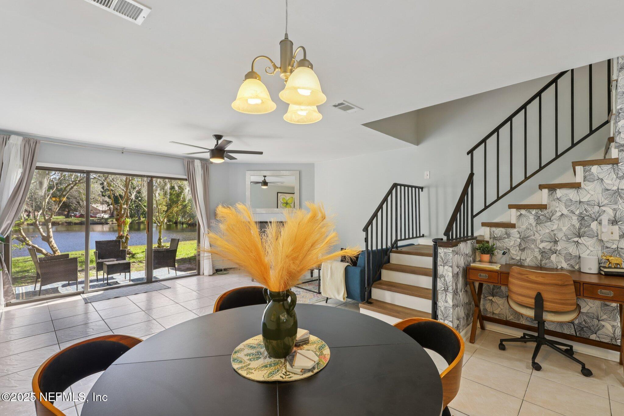 3801 Crown Point Road, Unit 1263 Jacksonville, FL 32257 - Photo 12 of 33 a view of a dining room with furniture a chandelier and large windows