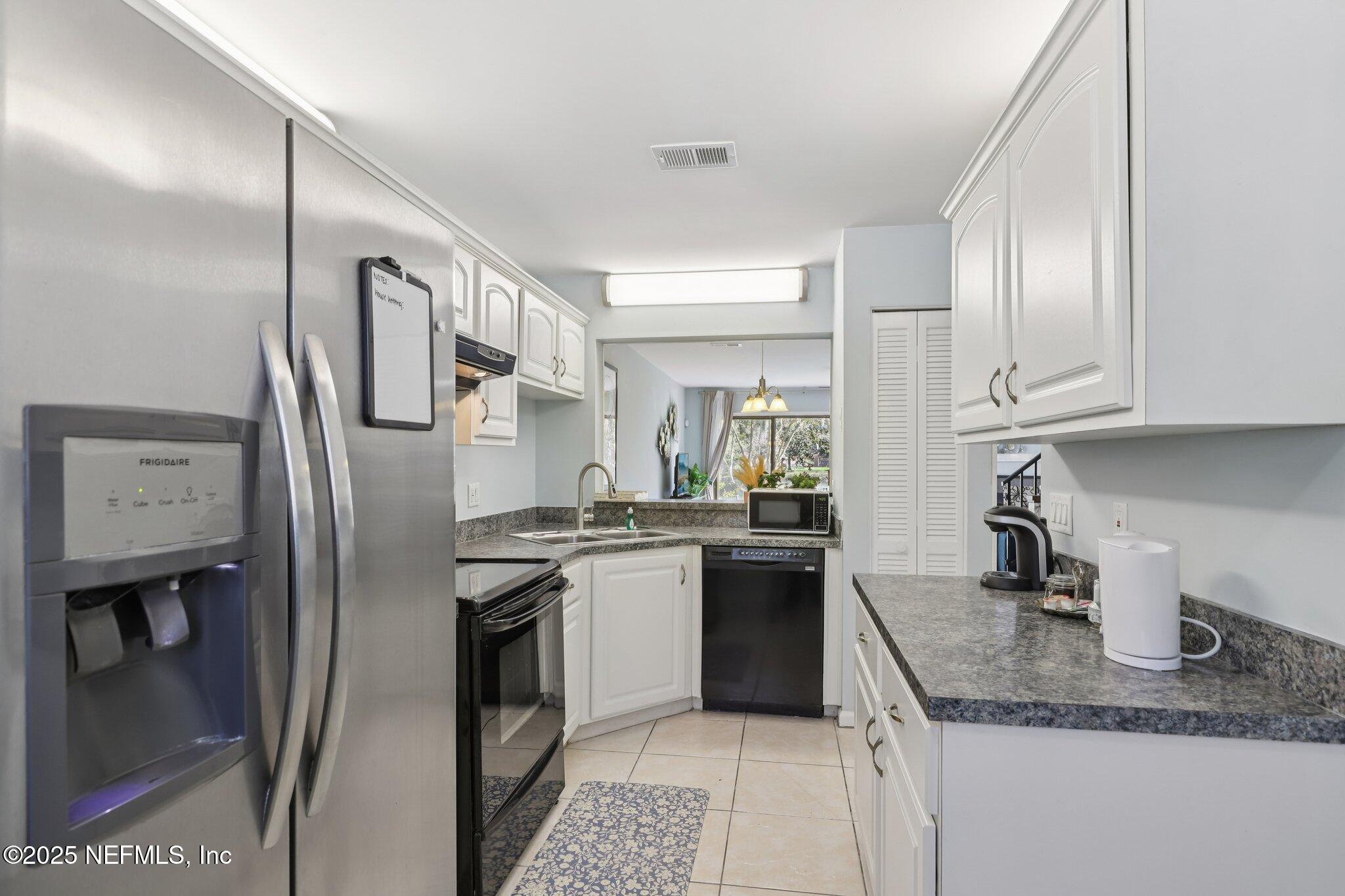 3801 Crown Point Road, Unit 1263 Jacksonville, FL 32257 - Photo 7 of 33 a kitchen with stainless steel appliances granite countertop a refrigerator a stove and a sink