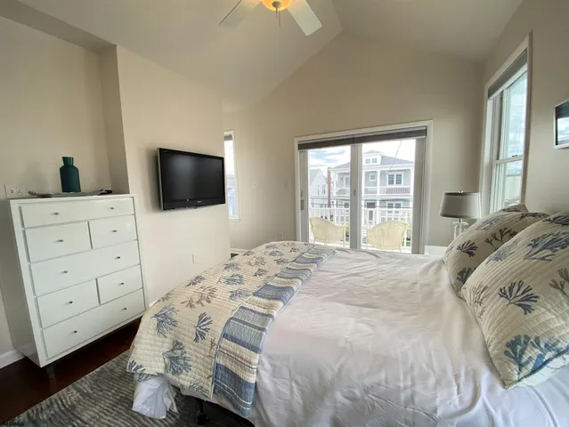 a bedroom with a bed and a flat tv screen on dresser