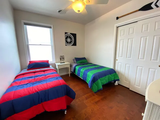 a bedroom with 2 bed and a lamp