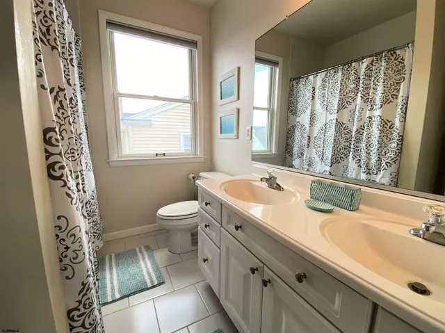 a bath room with a sink a toilet and a mirror