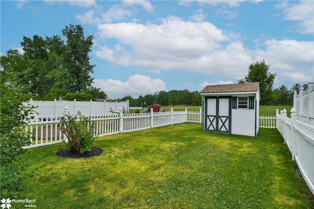 507 Howertown Road Northampton, PA 18067 - Photo 40 of 46 A well-maintained grassy yard is encircled by charming white picket fencing, featuring a functional storage shed.