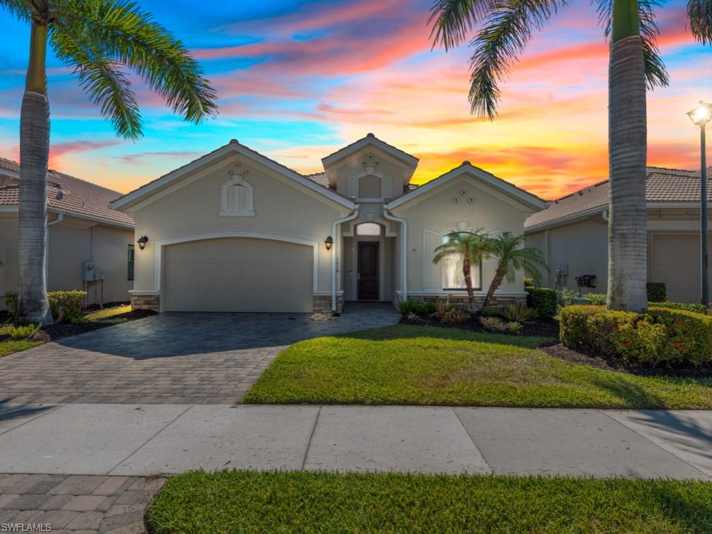 a view of a white house next to a yard with palm trees