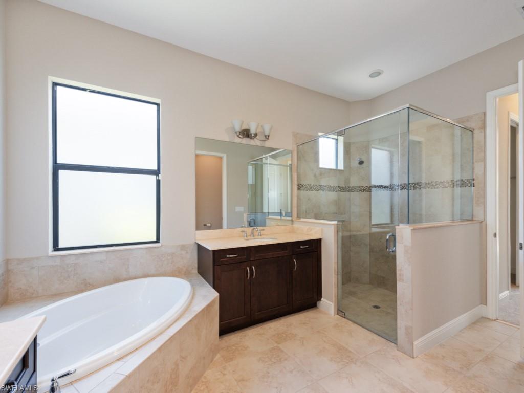 1638 Serrano Circle Naples, FL 34105 - Photo 17 of 23 a bathroom with a tub sink shower and mirror