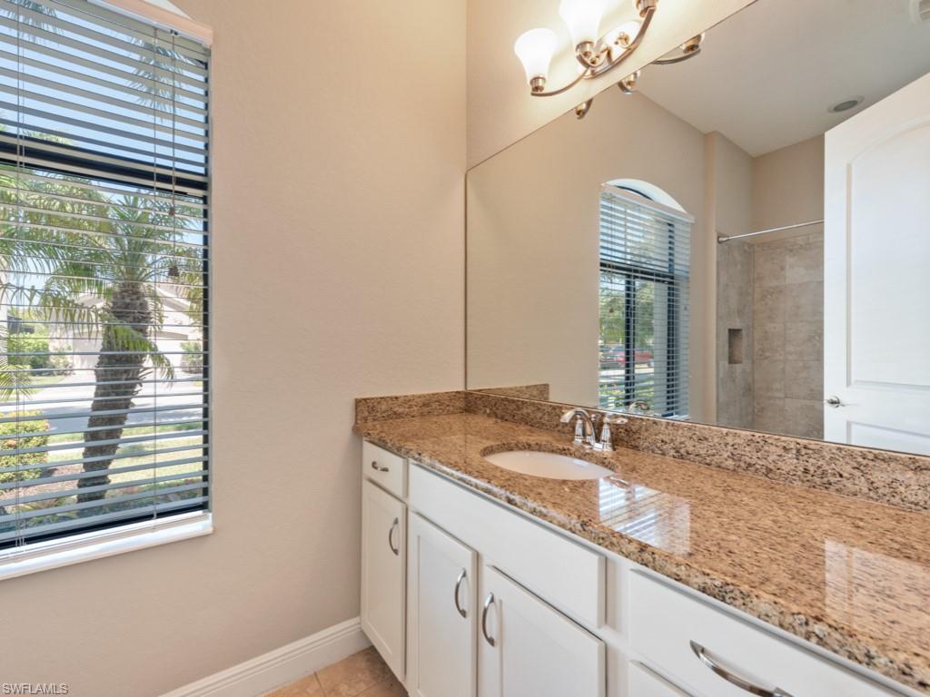 1638 Serrano Circle Naples, FL 34105 - Photo 19 of 23 a bathroom with a granite countertop sink and a mirror