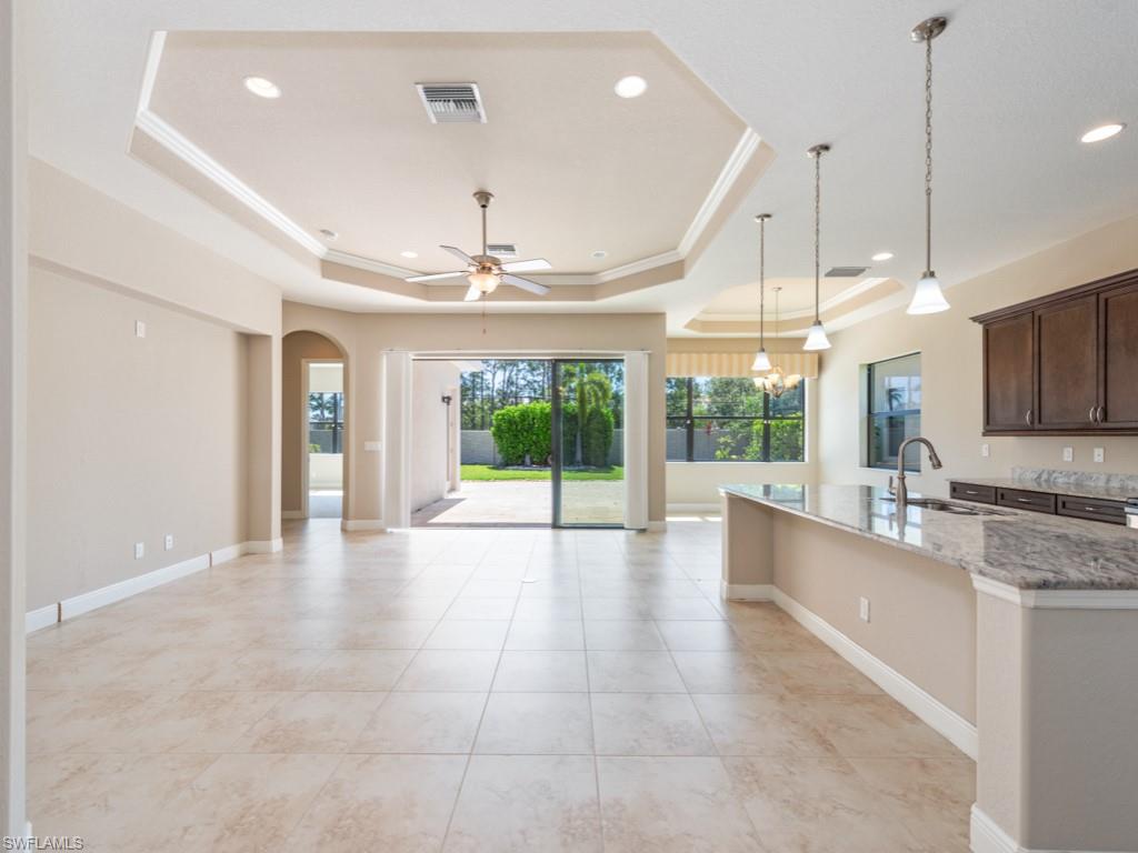 1638 Serrano Circle Naples, FL 34105 - Photo 9 of 23 a large kitchen with kitchen island granite countertop a large window and stainless steel appliances