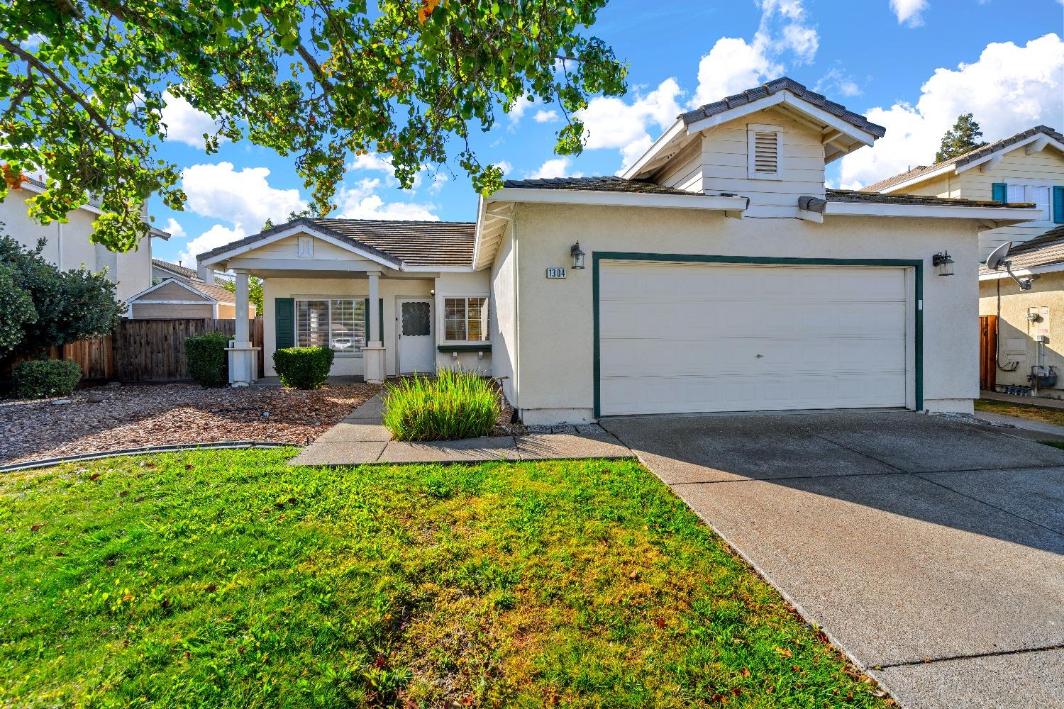a front view of a house with a garden and plants