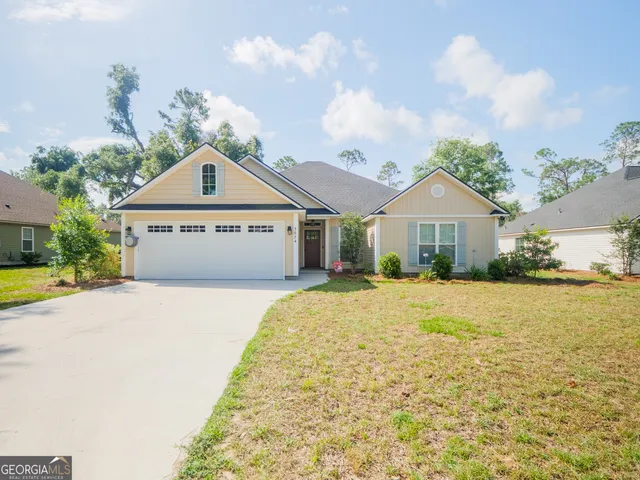 a front view of a house with a yard and garage