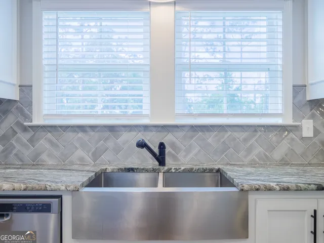 a view with granite countertop a sink and a window