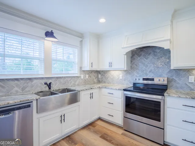 a kitchen with granite countertop a stove sink and cabinets