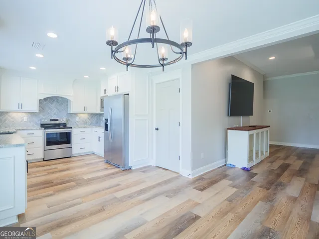 a kitchen with stainless steel appliances kitchen island a refrigerator and a stove top oven
