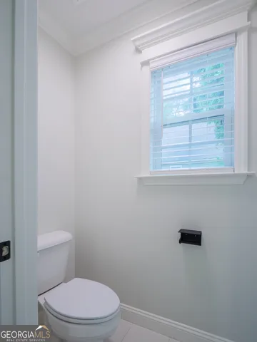 a white toilet sitting next to a window