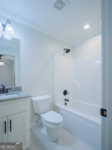 a bathroom with a granite countertop toilet a sink and a bathtub