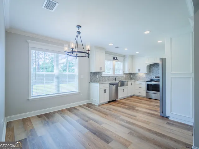 a open kitchen with white cabinets granite counter tops and a window