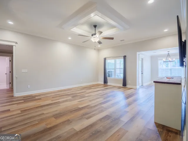a view of an empty room with window and wooden floor