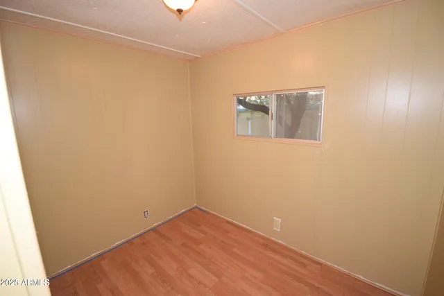 a view of a small space with wooden floor and a window