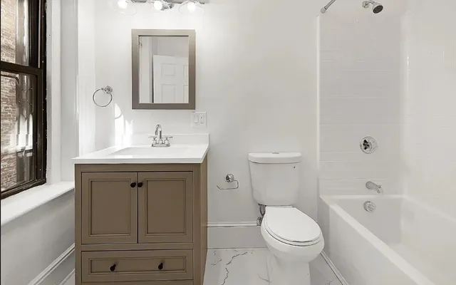 a bathroom with a sink a toilet and shower