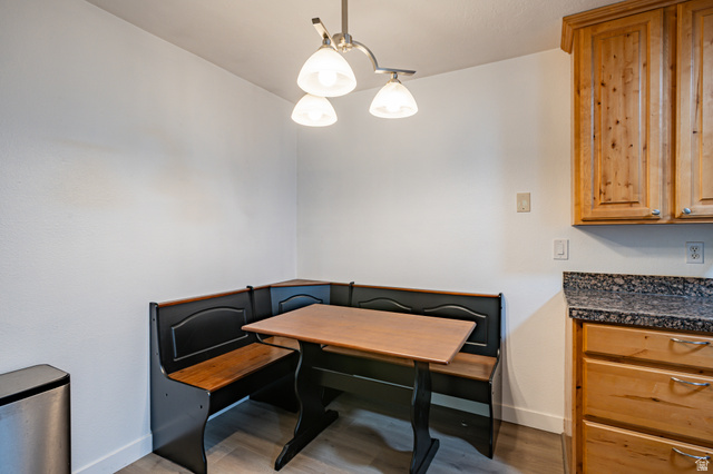 1221 Waterside Cove, Unit 11 Midvale, UT 84047 - Photo 8 of 23 Built-in breakfast nook with a wood-finish table and seating, illuminated by an overhead pendant light fixture