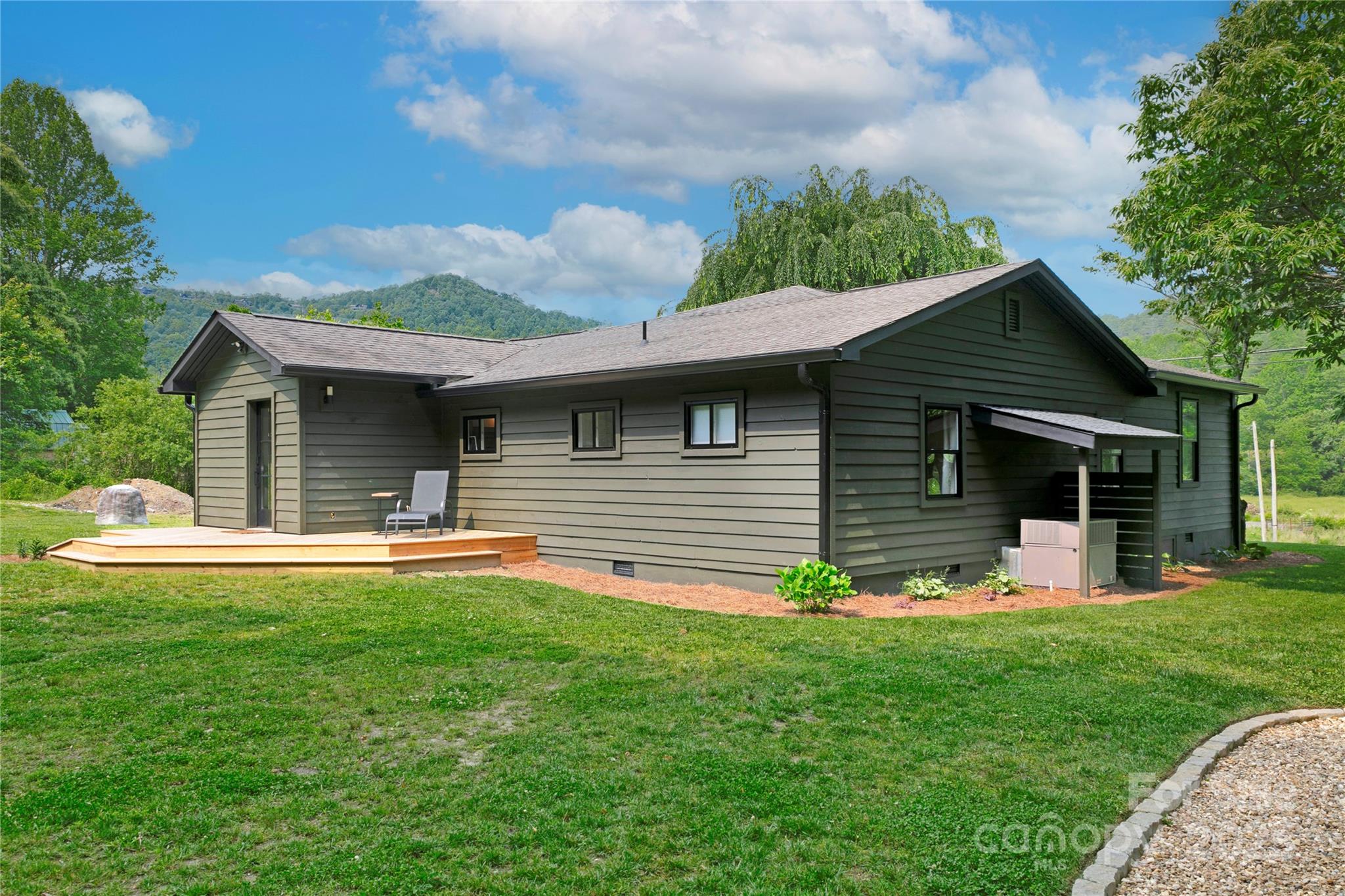 903 Middlefork Road Brevard, NC 28712 - Photo 32 of 45 a front view of a house with a garden and chairs