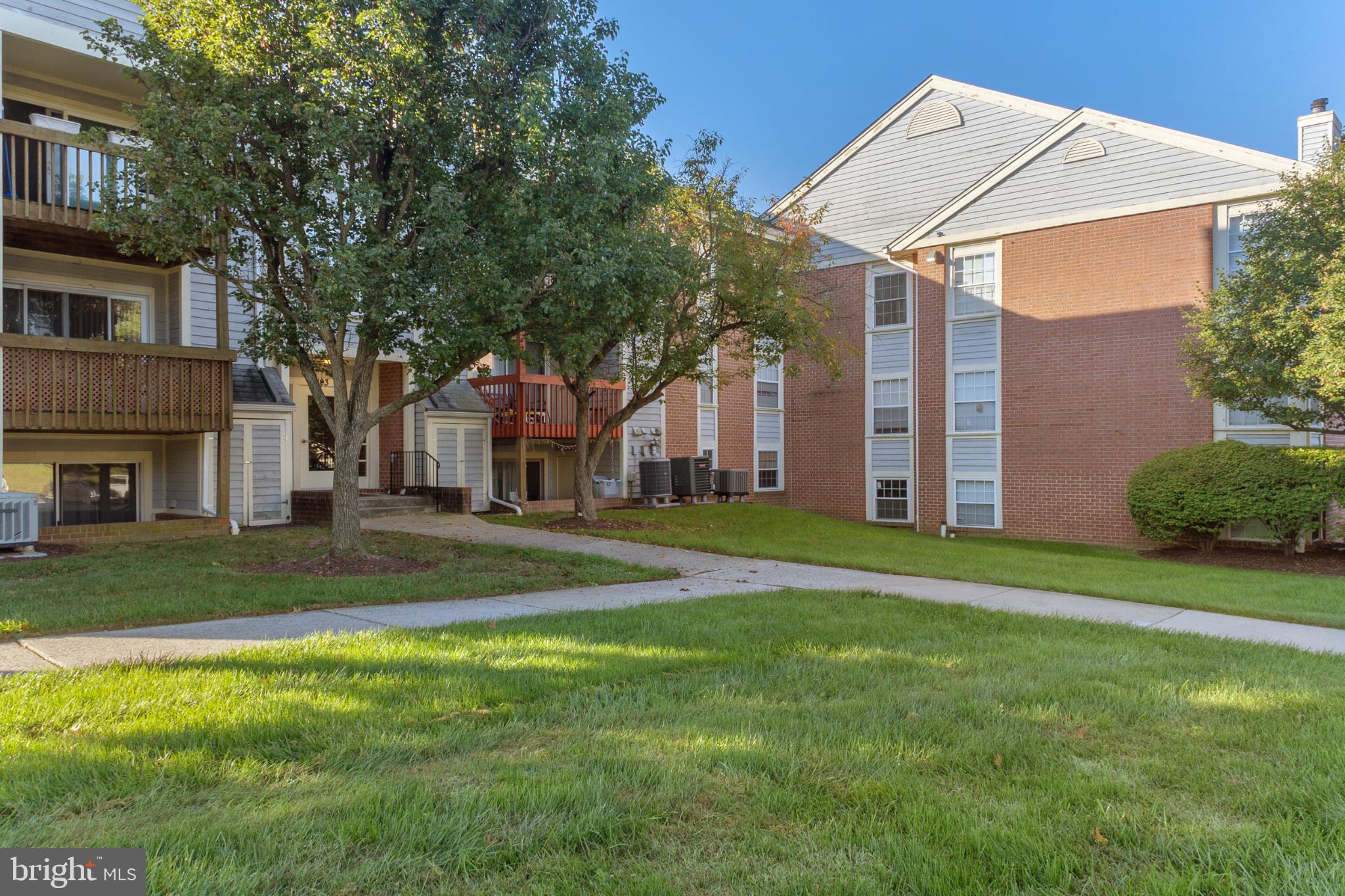 103 Three Coin Way, Unit 104 Glen Burnie, MD 21060 - Photo 18 of 19 a view of a house with a yard and tree s