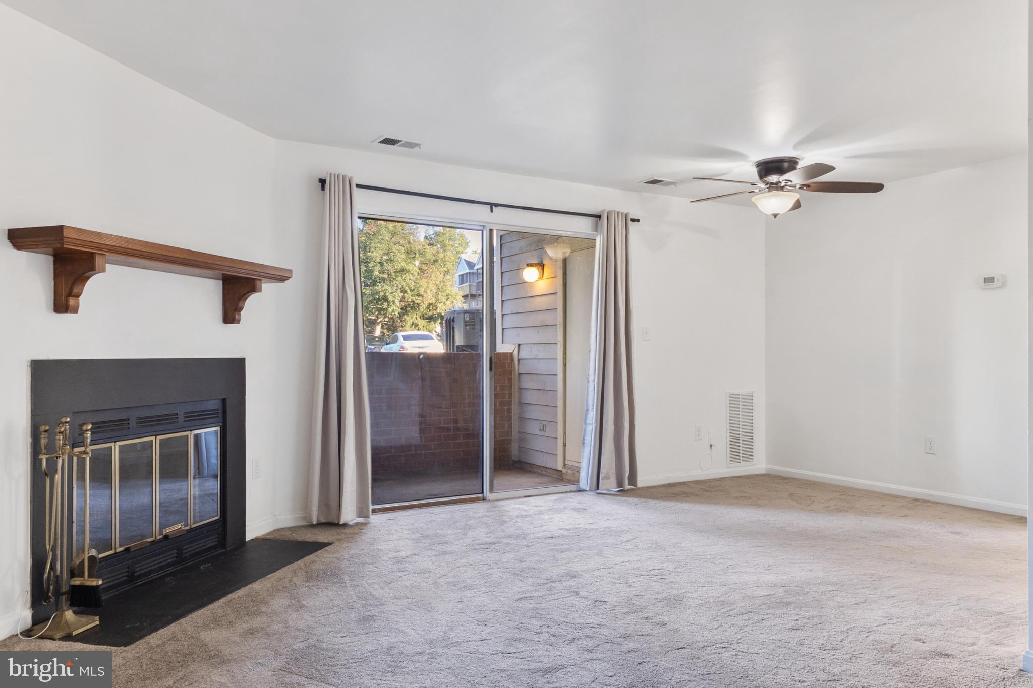 103 Three Coin Way, Unit 104 Glen Burnie, MD 21060 - Photo 2 of 19 an empty room with windows and a fireplace