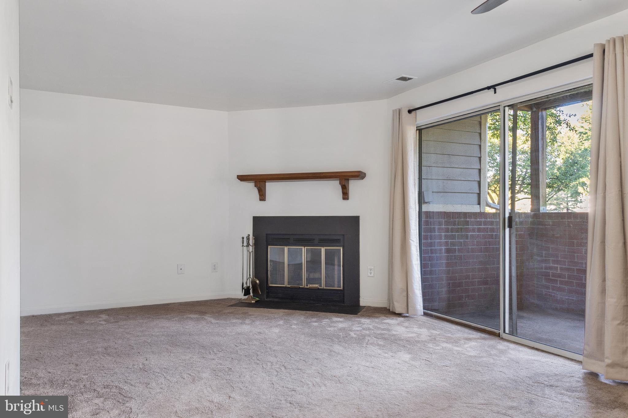 103 Three Coin Way, Unit 104 Glen Burnie, MD 21060 - Photo 3 of 19 a view of an empty room with a fireplace